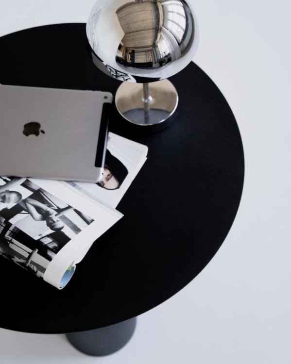 Detal stolika metalowego NØDE SLIM. Okrągły blat, smukła cylindryczna podstawa i minimalistyczna forma inspirowana współczesnym designem.