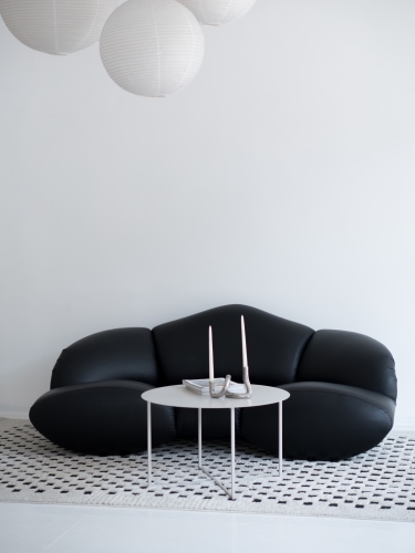 Stolik kawowy LOOM LOW marki CHROMA FØRM w aranżacji nowoczesnego wnętrza. Minimalistyczny metalowy stolik kawowy z dużym okrągłym blatem i lekką stalową podstawą, malowany proszkowo w drobnej strukturze.