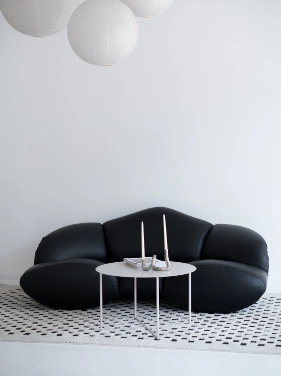 Stolik kawowy LOOM LOW marki CHROMA FØRM w aranżacji nowoczesnego wnętrza. Minimalistyczny metalowy stolik kawowy z dużym okrągłym blatem i lekką stalową podstawą, malowany proszkowo w drobnej strukturze.