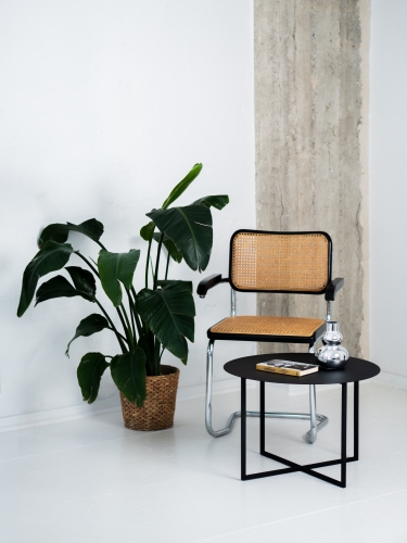 Stolik kawowy LOOM SLIM marki CHROMA FØRM w aranżacji nowoczesnego wnętrza. Minimalistyczny metalowy stolik z okrągłym blatem i geometryczną stalową podstawą, malowany proszkowo w drobnej strukturze.